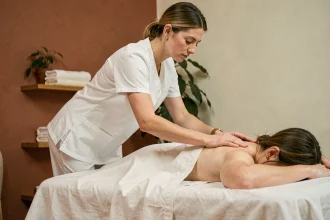 Masseuse professionnelle réalisant un massage sportif sur le dos d'un client dans un salon de massage à Toulouse