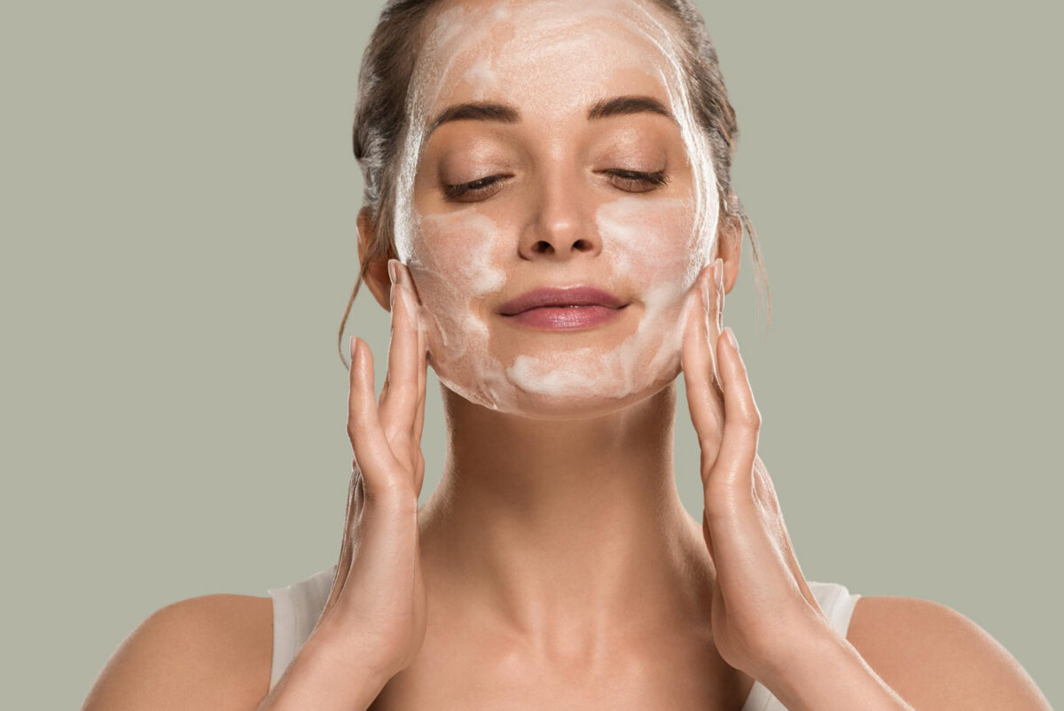 Une jeune femme se lave le visage avec un savon adapté